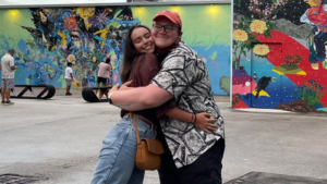 Brandon Penrod hugging Friend in front of Murals
